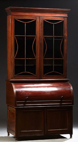 English Carved Mahogany Secretary Bookcase, 19th c., the stepped crown over double mullioned glazed doors, above a cylinder desk, op...