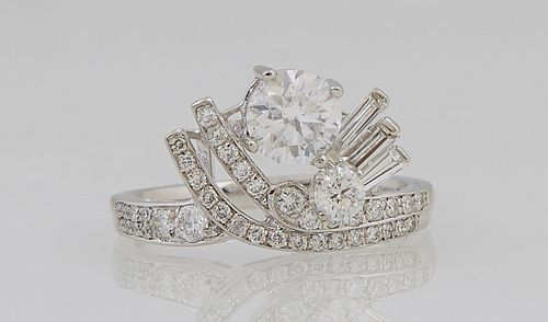 Unusual Platinum Lady's Dinner Ring, with a .82 carat round diamond flanked by two rounded diamond mounted rods left and three bague...