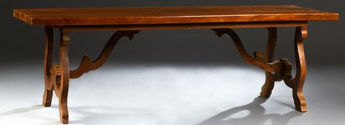 French Provincial Carved Walnut Monastery Table, 19th c., the thick top on scrolled trestle bases joined by curved stretchers, H. -...