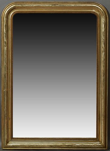 French Louis Philippe Gilt Pine Overmantel Mirror, 19th c., the wide arched frame with incised leaf and floral decoration, around a...