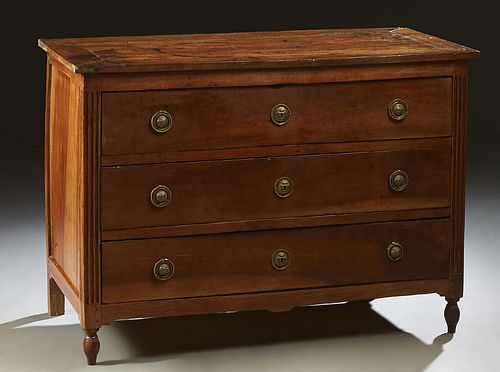 French Louis XVI Style Carved Walnut Commode, early 19th c., the rectangular top over three deep drawers flanked by reeded pilasters...
