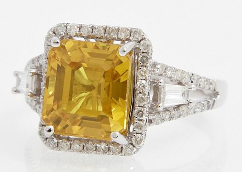 Lady's 14K White Gold Dinner Ring, with a 5.33 carat cushion cut yellow sapphire atop a border of pave diamonds, the pave diamond mo...