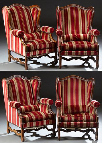Set of Four French Carved Walnut Wing Back Bergeres, 20th c., the arched back over cushioned upholstered rolled arms, to a cushion b...