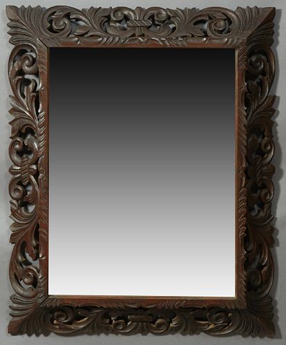 French Provincial Henri II Style Carved Beech Overmantel Mirror, late 19th c., the pierced leaf and scroll frame around a scroll and...