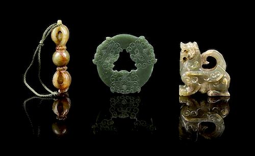 * A Group of Three Carved Jade Pendants Height of first 2 1/4 inches.