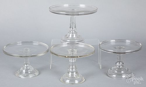 Four colorless glass cake stands