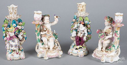 Two pairs of porcelain figural candlesticks