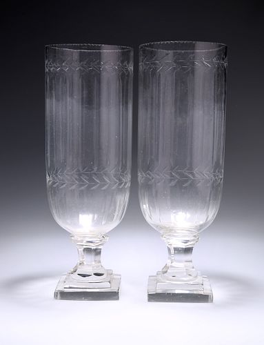 A PAIR OF CUT-GLASS VASES, each raised on stepped