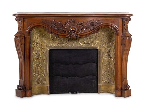 A Louis XV Style Carved Walnut and Pressed Gilt Metal Fireplace