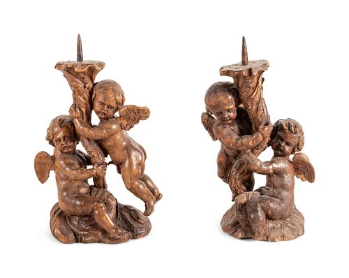 A Pair of Continental Carved Wood Cherubic Prickets