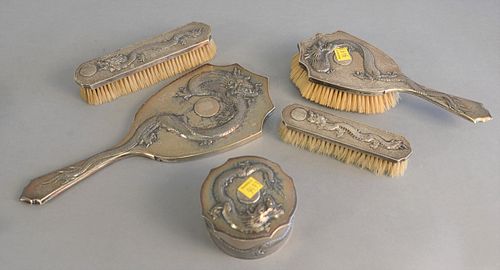 Five piece Tuck Chang Chinese Export to include silver dresser set, covered powder, 3 brushes and hand mirror, lg. 13", all with 3 claw dragon motif.