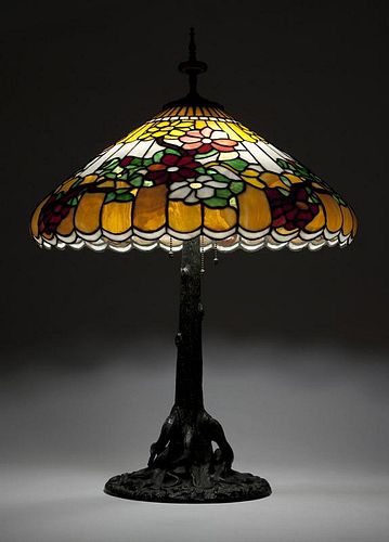 A patinated table lamp and leaded glass shade