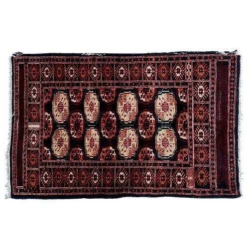 Tapete. Persia. Siglo XX. Estilo Bokhara. Elaborado en fibras de lana y algodón. Decorado con motivos geométricos. 147 x 96 cm