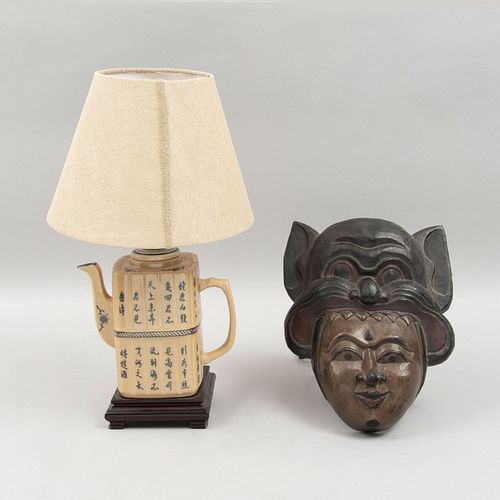Lote de 2 piezas orientales. Siglo XX. Consta de: Lámpara de mesa. Diseño a manera de tetera y máscara del Sudeste asiático.