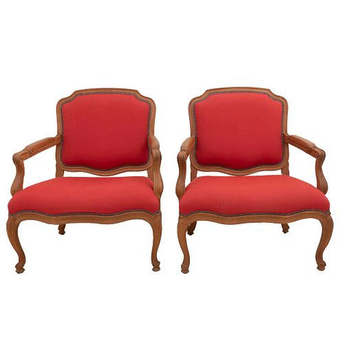 Pair of armchairs. 20th century. Carved in wood. With closed backrests and seats in red upholstery, semi-curved shafts.