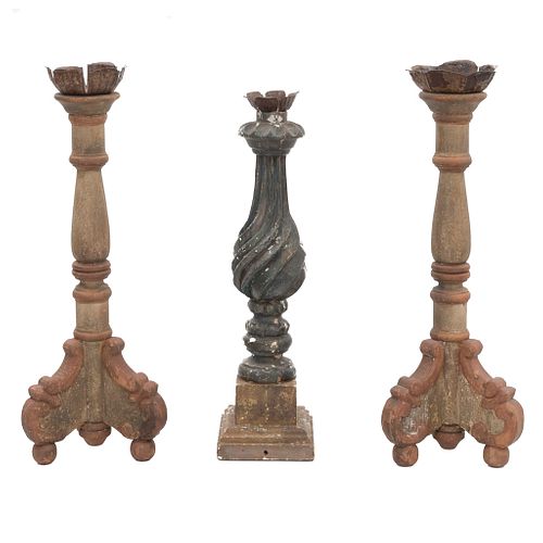 Lot of 3 candelholders. 20th century. Different designs. Carved in wood. With floral washers, 2 with architectural shafts.