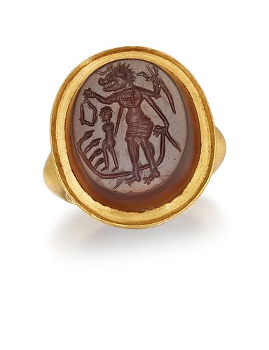 AN INTAGLIO HARDSTONE RING, the dark orange-brown agate slice, carved with 