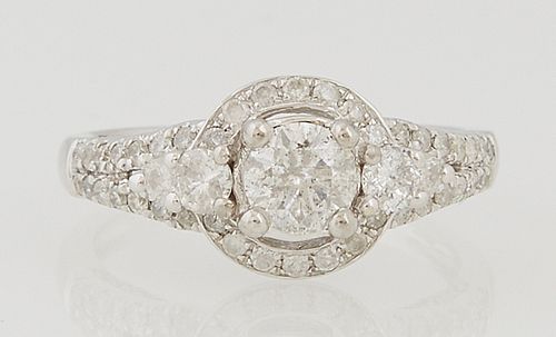 Lady's 14K White Gold Dinner Ring, with a central .53 carat round diamond atop a border of small round diamonds, flanked by diamond...