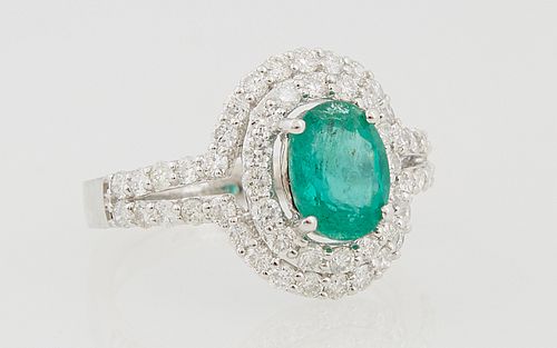 Lady's 18k White Gold Dinner Ring, with an oval 1.2 carat emerald atop two concentric graduated rows of round diamonds, and diamond...