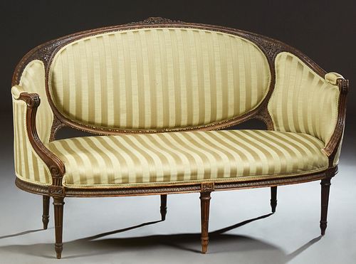 French Louis XVI Style Carved Walnut Settee, 19th c., the floral carved crest rail over an oval medallion cushioned back, flanked by curved upholstere