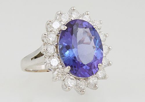 Lady's 18K White Gold Dinner Ring, with an oval 8.99 carat tanzanite, atop a border of round diamond "points" total diamond wt.- 2.1 cts., Size 7, wit