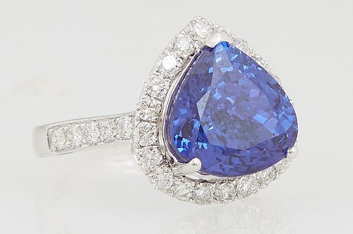 Lady's Platinum Dinner Ring, with a trillion cut 6.32 carat tanzanite atop a conforming border of round diamonds, the shoulders of the band also mount