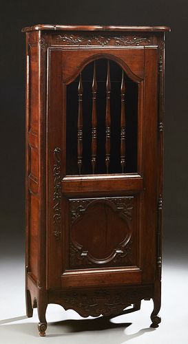 French Provincial Carved Walnut Bonnetiere, 19th c., the serpentine top over a single door with a spindled upper panel over a carved lower panel, long