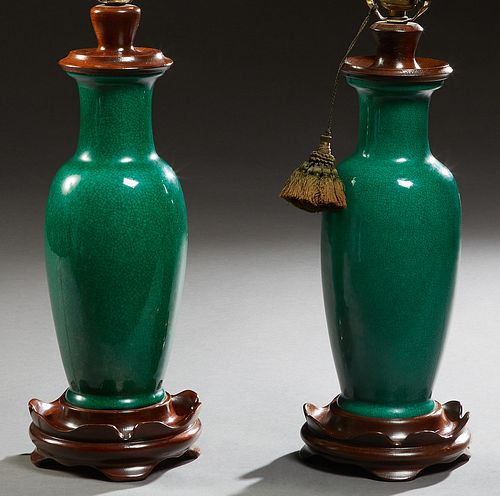 Pair of Chinese Vivid Green Porcelain Baluster Vases, 20th c., now mounted on carved wooden bases with four curved legs, and electrified as lamps, H.-