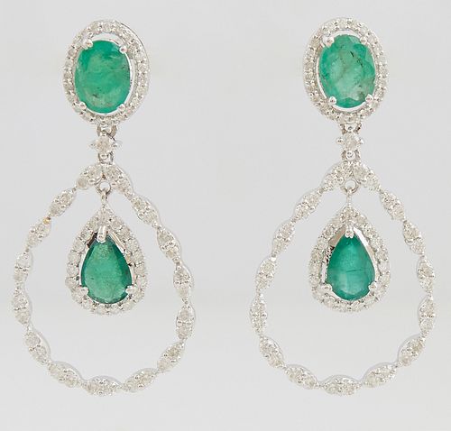 Pair of 14K White Gold Pendant Earrings, each with an oval emerald stud atop a border of small round diamonds, suspending a diamond mounted link and a