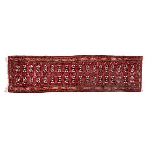Tapete de pasillo. Pakistán. Siglo XX. Estilo Boukhara. Elaborado en fibras de lana y algodón. 80 x 315 cm