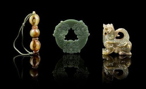 * A Group of Three Carved Jade Pendants Height of first 2 1/4 inches.