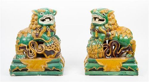 * A Pair of Sancai Pottery Fu Lions Height 15 1/4 x width 12 1/4 inches.