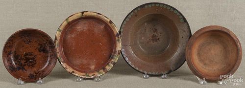 Four assorted Pennsylvania redware articles, to include three dishes and one flowerpot base