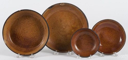 Four redware plates and shallow bowls, 19th c., ranging from 5'' - 9'' dia.