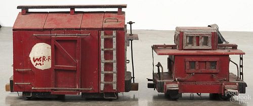 Two painted wood train model train cars, ca. 1900, with sliding doors, wheels, and plastic windows