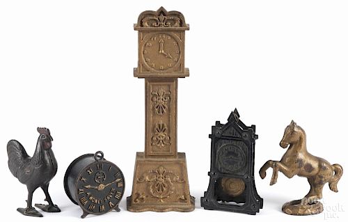 Five cast iron still banks, to include a tall clock, a tower clock, a rooster, a horse, and an alarm