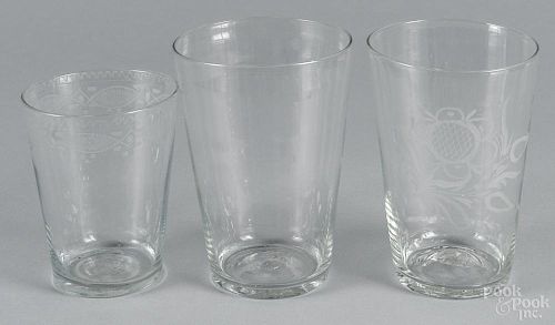 Three colorless flip glasses, 19th c., two with etched decoration, 5'' h., two - 6 1/4'' h.
