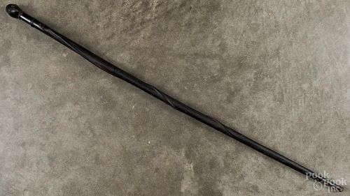Ebonized cane with a snake and human head grip, 36'' l. Provenance: DeHoogh Gallery, Philadelphia.