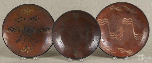 Three slip-decorated Pennsylvania redware pie plates, 19th c., largest - 10 1/2'' dia.