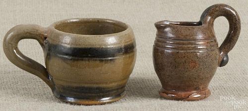 I. S. Stahl redware creamer, 3'' h., and handled cup, 2 1/4'' h.