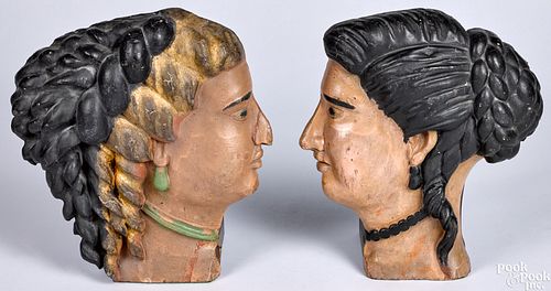 Pair of carved and painted profile female heads