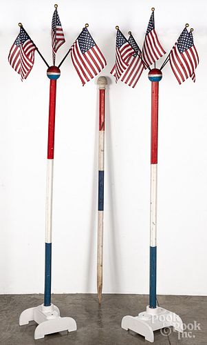 Three painted American flag display poles