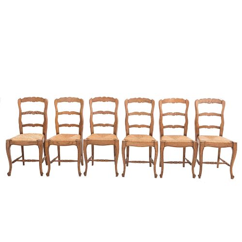 Lote de 6 sillas. Francia. Siglo XX. Estilo Luis XV. En talla de madera de roble. Con respaldos escalonados y asientos de palma.