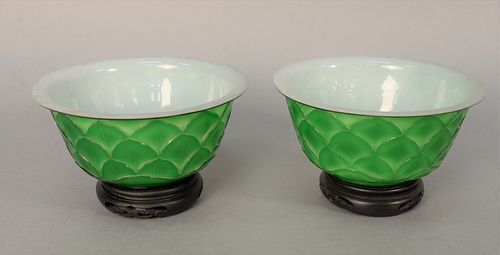 Pair of Chinese Peking Overlay Glass Bowls having green exterior carved with lotus petals and white interior glass on carved wood st...