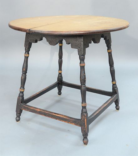 Tavern Table having round maple top on over scalloped apron set on turned splayed legs with box stretcher on round feet, in old black paint with gold 