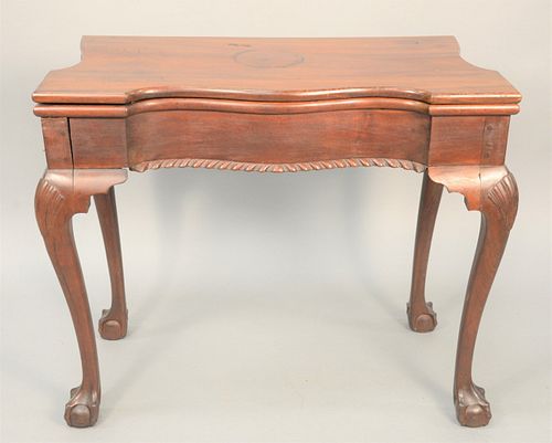 Mahogany Games Table having shaped top with serpentine front over conforming frieze with gadrooned between cabriole legs ending in b...