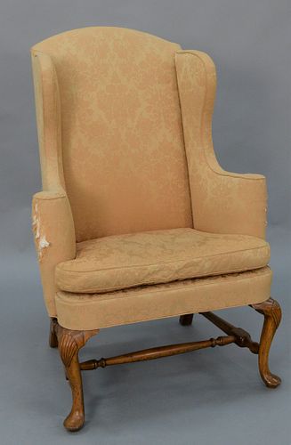 Queen Anne Upholstered Wing Chair with cone shaped arm rests, upholstered with loose cushion set on shell carved cherry cabriole leg...