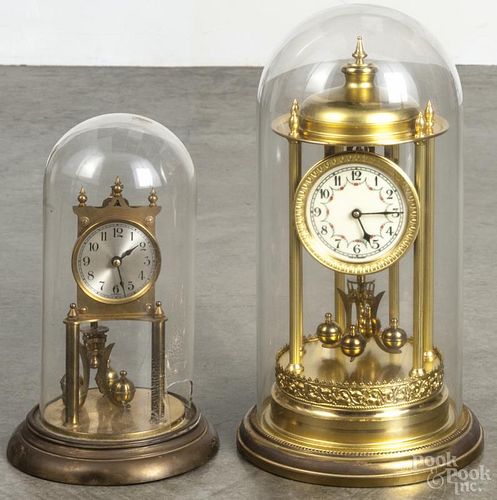 Two German anniversary clocks, both under domes, 16 1/4'' h. and 12 1/2'' h.
