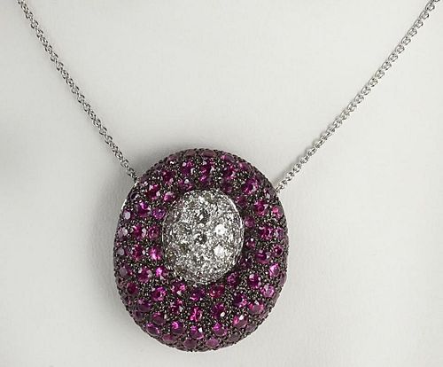 Lady's modern design round cut ruby, diamond and 18 karat white gold pendant necklace.