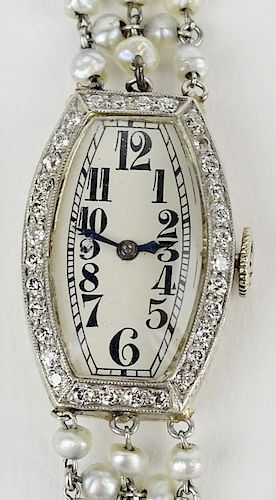 Lady's Edwardian platinum, diamond and seed pearl Movado Swiss bracelet watch.